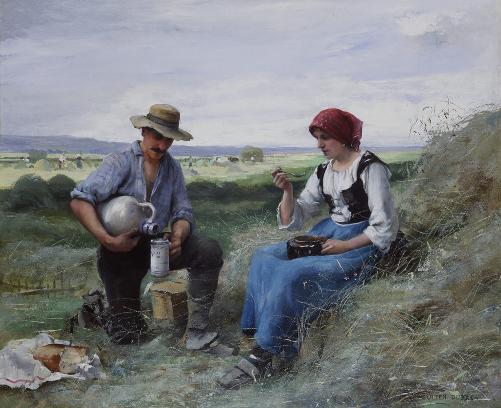 man and woman having lunch in a field