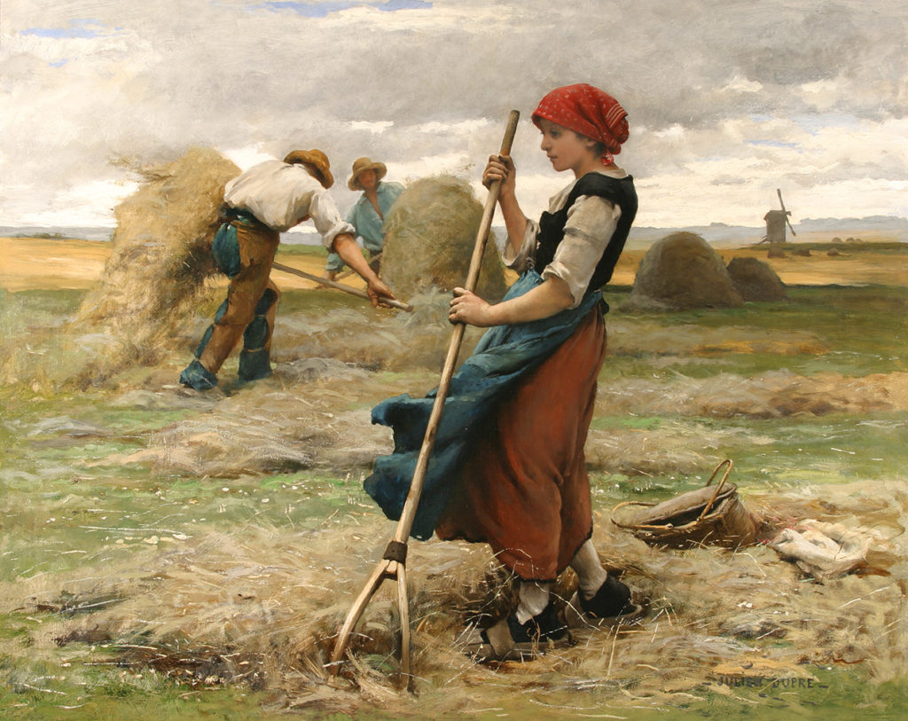 woman raking hay in a field with two men